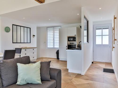 un salon avec un canapé et une cuisine dans l'établissement Maison familiale La Belle Vie jacuzzi/sauna, à Saint-Gilles-Croix-de-Vie