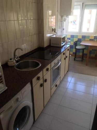 a kitchen with a sink and a washing machine at Mar y Montaña in Laredo