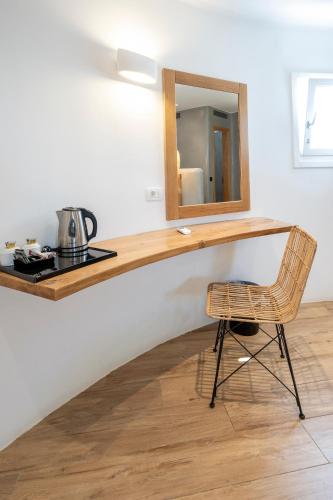 a mirror and a chair in a room at Smy Mediterranean White Santorini in Kamari