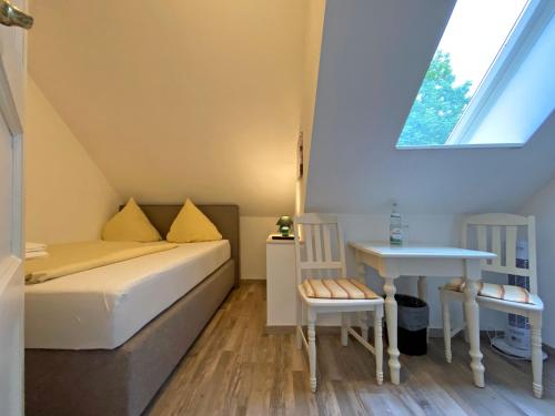 a small room with a bed and a table at RATAGS Kunsthandwerkerhaus in Langenwolmsdorf