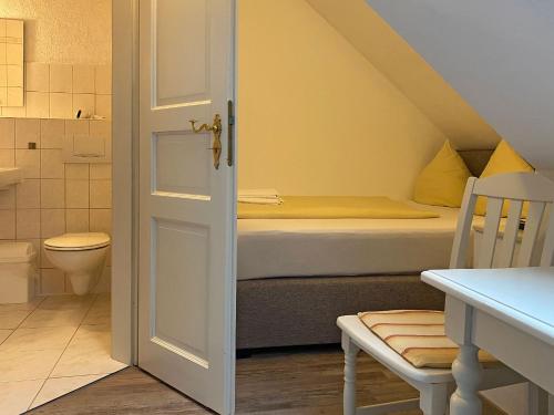 a bathroom with a bed and a toilet in a room at RATAGS Kunsthandwerkerhaus in Langenwolmsdorf