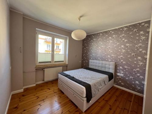 a bedroom with a bed with a floral accent wall at Gdynia Centrum ul. Pomorska in Gdynia