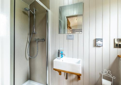 a bathroom with a sink and a shower at The Little John Petite Cosy log Cabin Romantic Stay Sleeps 2 Near Sherwood Forest at Fairview Farm Nottingham set in 88 acres in Blidworth
