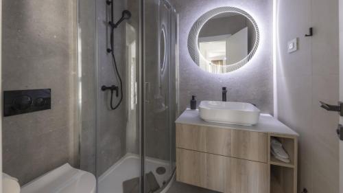 uma casa de banho com um lavatório, um chuveiro e um espelho. em Mare Solis Pinea em Mali Lošinj