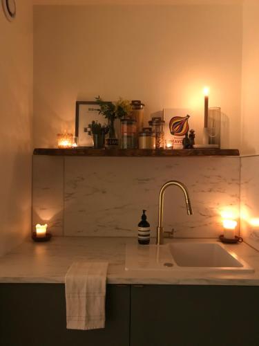 a kitchen counter with two candles and a sink at LuxeLevallois chic stay with balcony 800 meters from Paris in Levallois-Perret