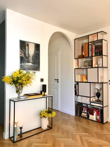 un salon avec une étagère et des livres dans l'établissement LuxeLevallois chic stay with balcony 800 meters from Paris, à Levallois-Perret