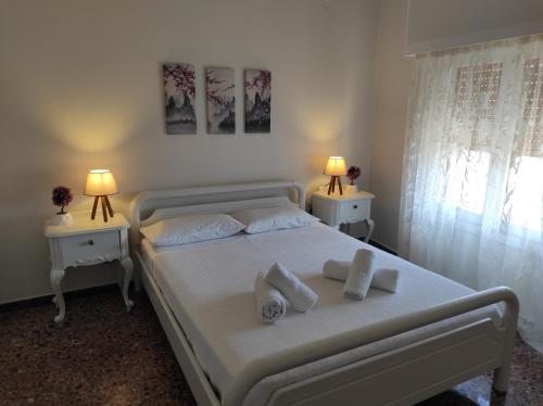 ein Schlafzimmer mit einem weißen Bett und zwei Nachttischen in der Unterkunft Aurora nest in Gaios