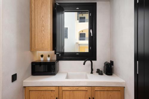 a kitchen with a sink and a microwave at La Torretta Suites & Spa in Pirgos