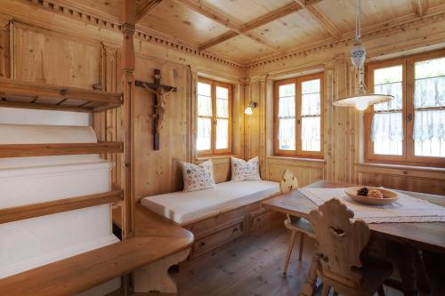 a wooden cabin with a table and a bunk bed at Residence Untermösslhof in Lana
