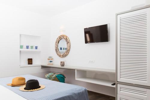 a bedroom with a bed with a hat on it at Lindos Del Mar Suites - Adults Only in Lindos