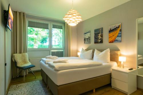 - une chambre avec un lit, une chaise et une fenêtre dans l'établissement Strand-Park Strand-Park 113, à Heringsdorf