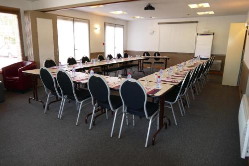 a conference room with long tables and chairs at Kyriad Rouen Sud - Oissel in Saint-Étienne-du-Rouvray