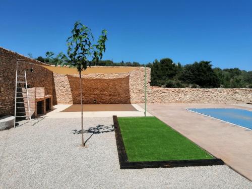 un jardin avec un petit arbre et une piscine dans l'établissement Casa Rural Moli, à Rosell