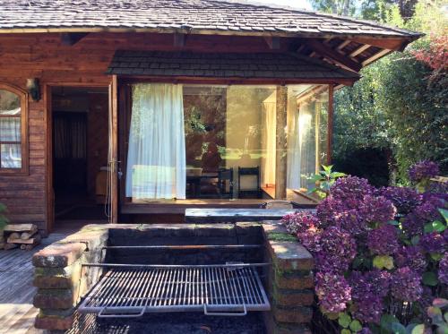 a screened in porch of a house with flowers at Cabañas Playa Linda in Pucón