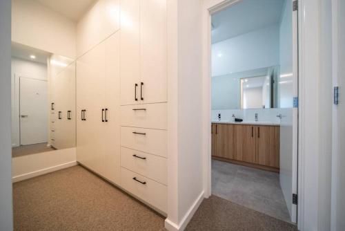 a bathroom with white cabinets and a sink at SYLO Luxury Apartments - 1Gb Fibre Internet in Adelaide