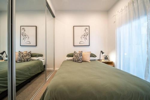 a bedroom with two beds and a glass wall at SYLO Luxury Apartments - 1Gb Fibre Internet in Adelaide