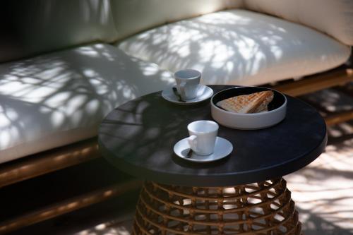 uma mesa com uma tigela de pão e duas chávenas em The Sanctuary Urban Retreat em Roma