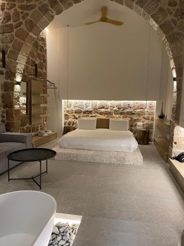 a bedroom with a bed and a tub in a room at Akotika boutique in ‘Akko