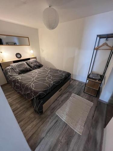 une chambre avec un lit et un parquet dans l'établissement Appartement Montignac Lascaux, à Montignac