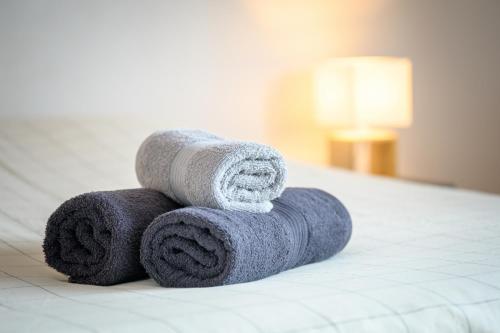 un mucchio di asciugamani impilati su un letto di Appart le Grignon a Saint-Martin-de-Ré