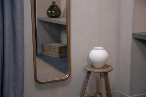 a vase sitting on a stool in front of a mirror at The Sanctuary Urban Retreat in Rome