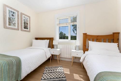 a bedroom with two beds and a window at Cottage 446 - Letterfrack in Letterfrack