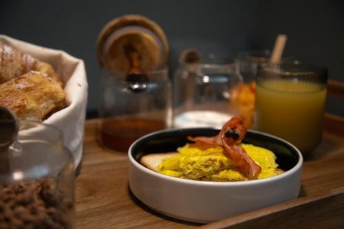 a bowl of food on a table with bread and orange juice at The Sanctuary Urban Retreat in Rome