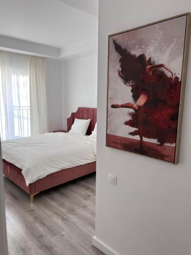 a bedroom with a bed and a painting on the wall at Cosmopolis Bliss: Your Home Away from Home in Ştefăneştii de Jos