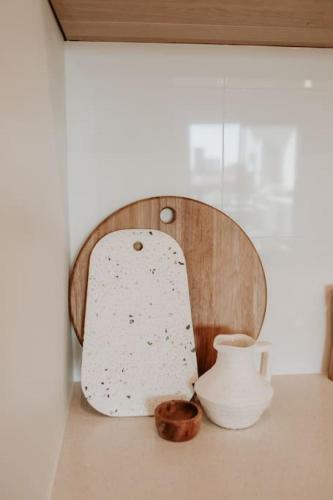 a table with a bowl and a vase on it at SYLO Luxury Apartments - Penthouse LVL 3 in Adelaide
