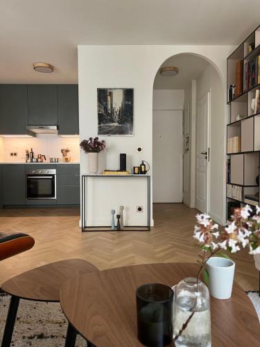 a living room with a table and a kitchen at LuxeLevallois chic stay with balcony 800 meters from Paris in Levallois-Perret