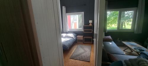 uma sala de estar com um sofá e duas janelas em Zawady Oleckie- Ostoja em Kowale Oleckie