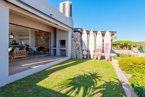 a house with surfboards on the side of it at Beach Breakaway Apartment in Langebaan