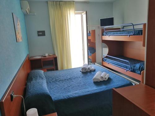 1 Schlafzimmer mit 2 Etagenbetten und 2 Schuhpaaren in der Unterkunft Megaron Hotel in Pozzallo