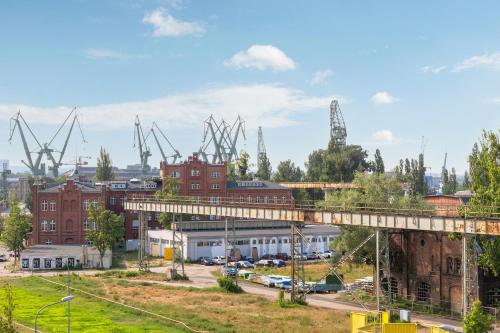 a view of a city with a bridge and buildings at DOKI Living & Foodhall by Downtown Apartments in Gdańsk