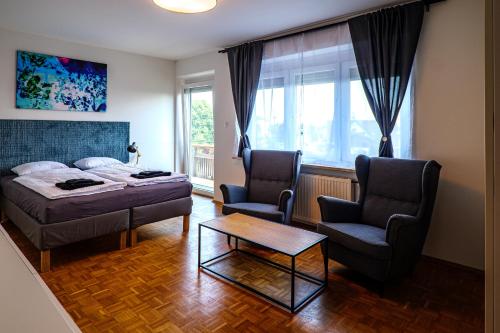 - une chambre avec un lit, deux chaises et une table dans l'établissement Flataid Gästehaus Graschi - Steinbergstraße, à Graz