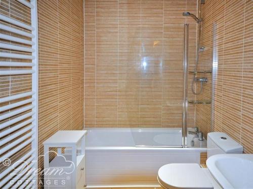 La salle de bains est pourvue d'une baignoire, d'une douche et de toilettes. dans l'établissement Admiral's Quarter Apartment 5, à Weymouth
