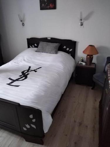 a bedroom with a bed with a black and white comforter at Gîte Chez Nathalie in Oye-Plage