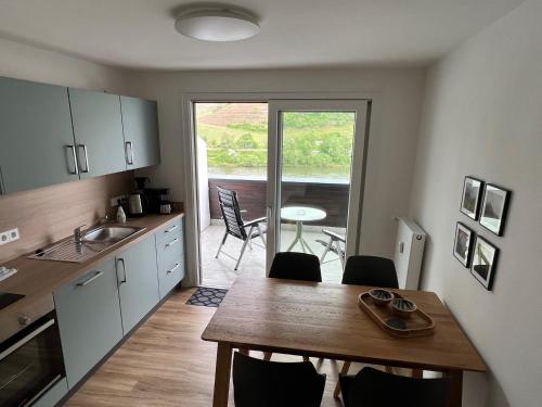 a kitchen with a wooden table and a dining room at Hotel Haus Erholung in Cochem