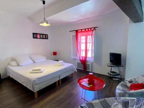 1 dormitorio con cama y ventana roja en Appartements Pech Mary, en Carcassonne