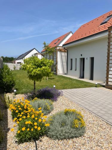 a garden with yellow flowers and a house at Dream Apartman in Levél