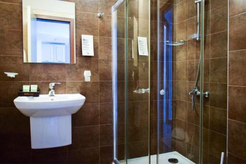 een badkamer met een douche en een wastafel bij ОАЗИС РИЗОРТ&СПА-премиум апартаменти с гледка море in Lozenets