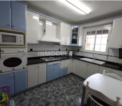 a kitchen with white cabinets and a stove top oven at Casa La Torre de la Balsa de Cela in El Canalito
