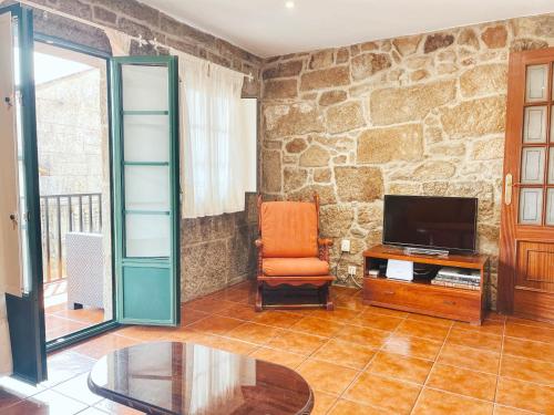 sala de estar con pared de piedra en CASA CASTAÑEIRA, en Combarro
