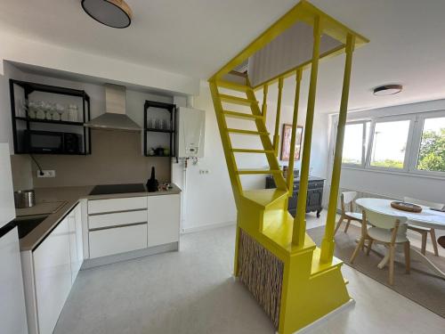 a yellow staircase in a kitchen with a table at Design apartment with garage in Santander