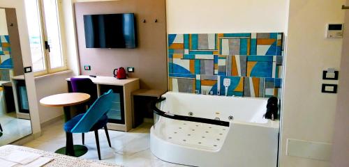 a bathroom with a tub and a table and a stool at HOTEL HOUSE GARGANO in San Giovanni Rotondo