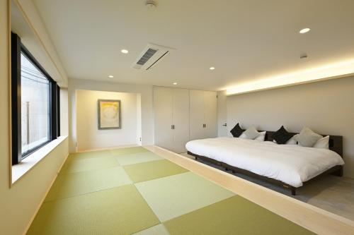 a bedroom with a large bed and a large window at Mont-モン-KAMOGAWA STAY and HOTEL in Kyoto
