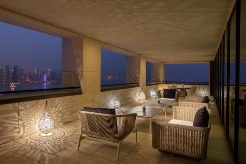 a living room with couches and a view of the city at Park Hyatt Doha, Msheireb Downtown in Doha