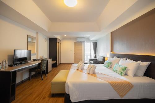 Habitación de hotel con cama grande y escritorio. en Golden Jade Suvarnabhumi en Lat Krabang