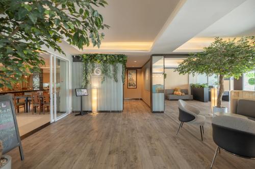an office lobby with tables and chairs and trees at Golden Jade Suvarnabhumi in Lat Krabang