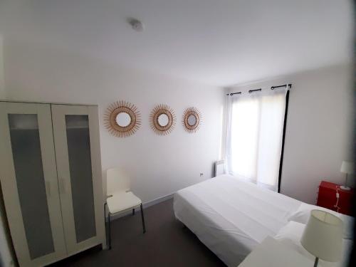 une chambre avec un lit, une fenêtre et un miroir dans l'établissement La Marina avec Parking et accès Piscine, à La Rochelle